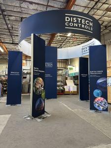 RENTAL: Modified ECO-4126 Island Design with Gravitee Storage Tower @ 72" Wide x 42" Deep x 190" High, (4) Double-Sided Kiosk Towers @ 3 ft. Wide x 12 ft. High, (2) Large Monitor Mounts, Circular Sign @ 18 ft/ Diameter x 42 in. High, SEG Fabric Graphics,